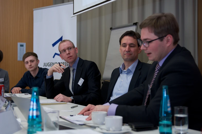 men sitting at a conference table having a discussion