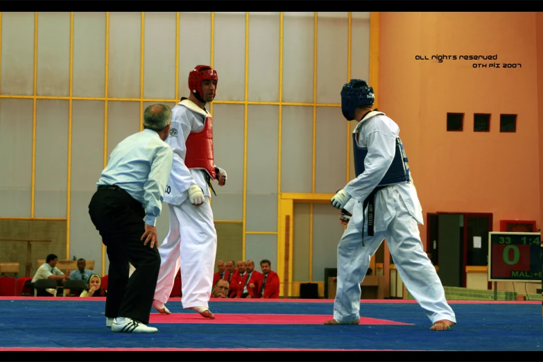 two men are in a karate court on mats