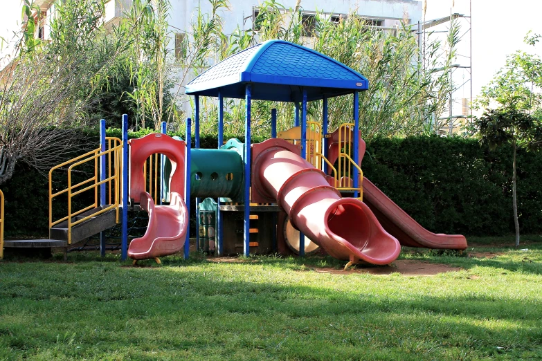 a colorful playground has a slide and a climbing ladder