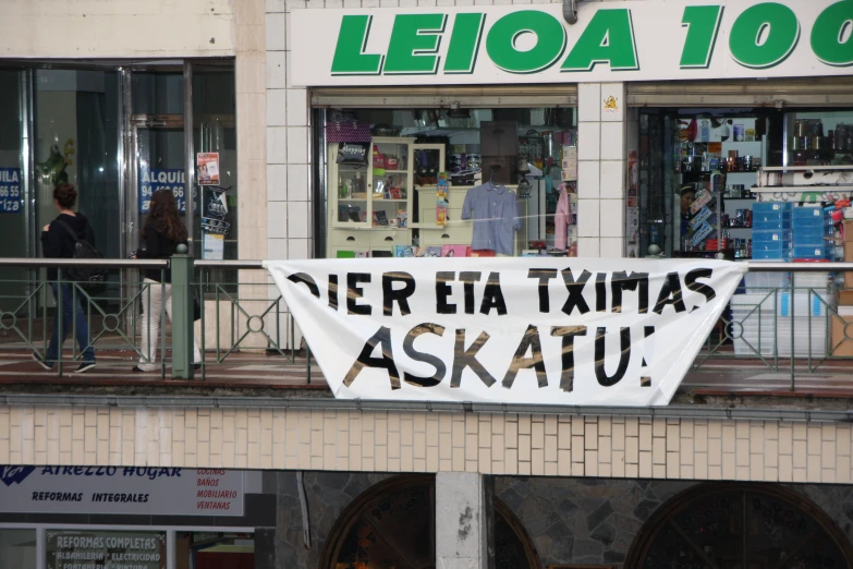 a white banner with black words on it and a window behind it
