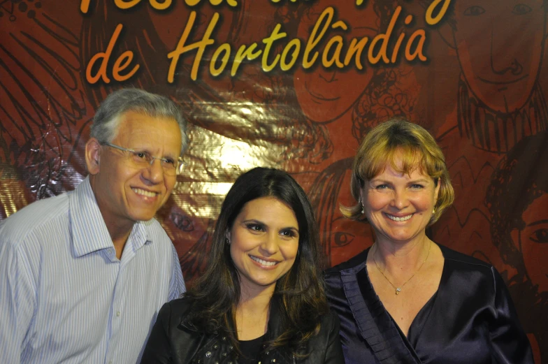 two woman and a man smiling for the camera