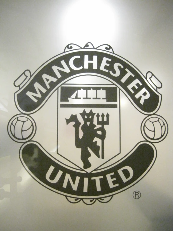 the manchester united logo as reflected in a glass