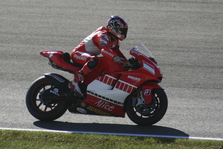 a person in red riding a red motorcycle on the side of the road