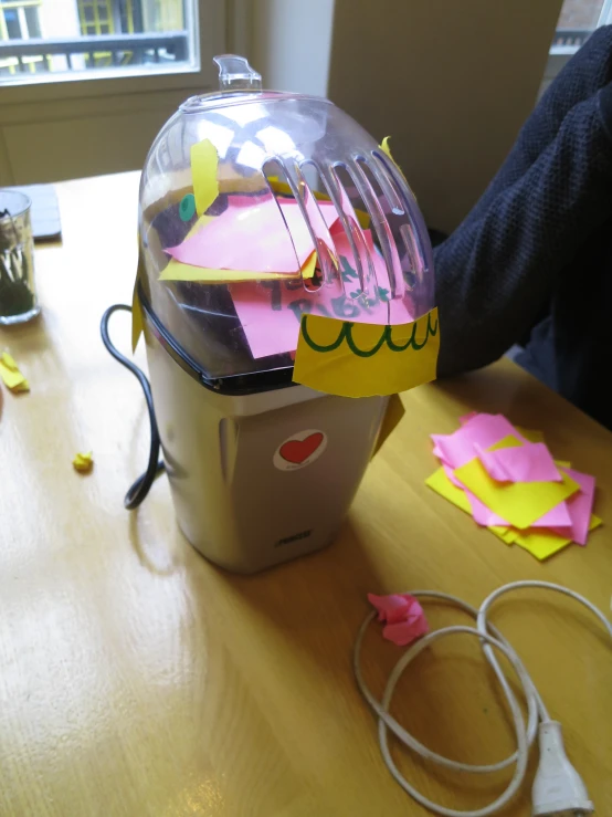 an office desk with pink and yellow sticky notes