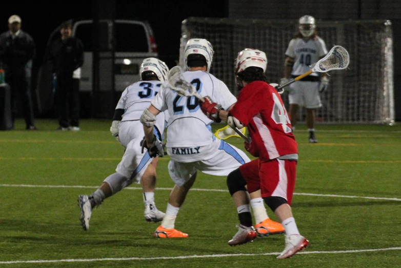 a group of people playing lacrosse in a field