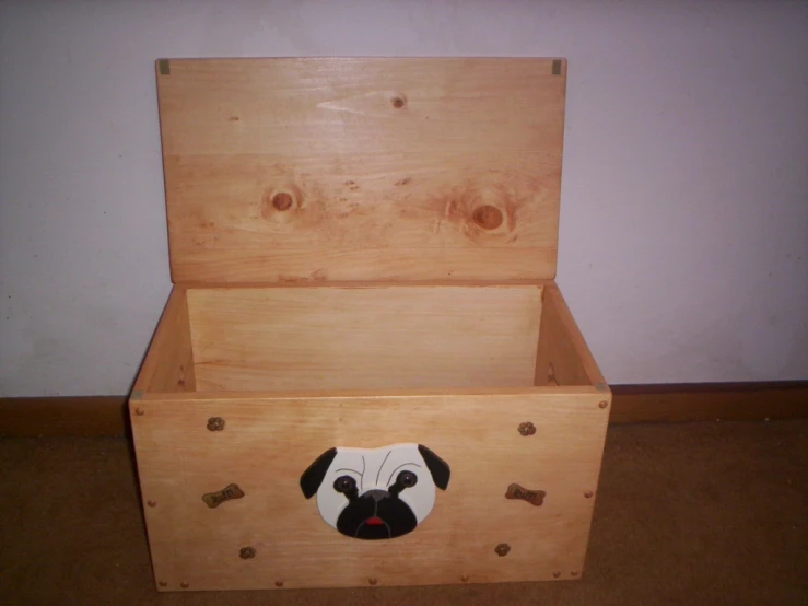 a wooden toy chest with a face painted on it