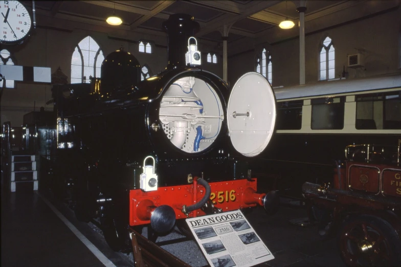 a black train parked inside of a building next to large windows