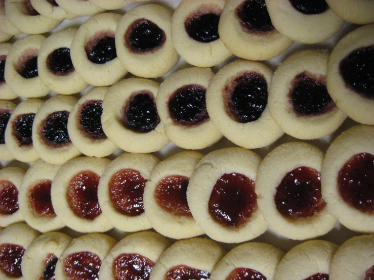 a number of cookies covered in jelly next to each other