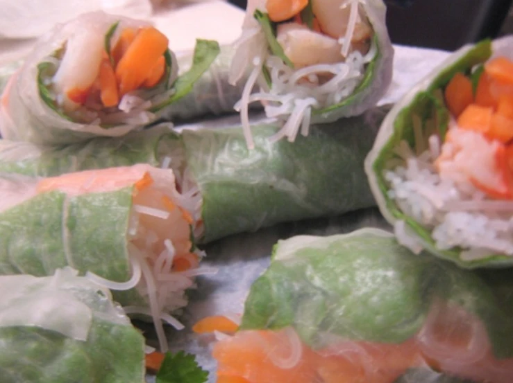 a white plate topped with vegetable rolls on top of a table