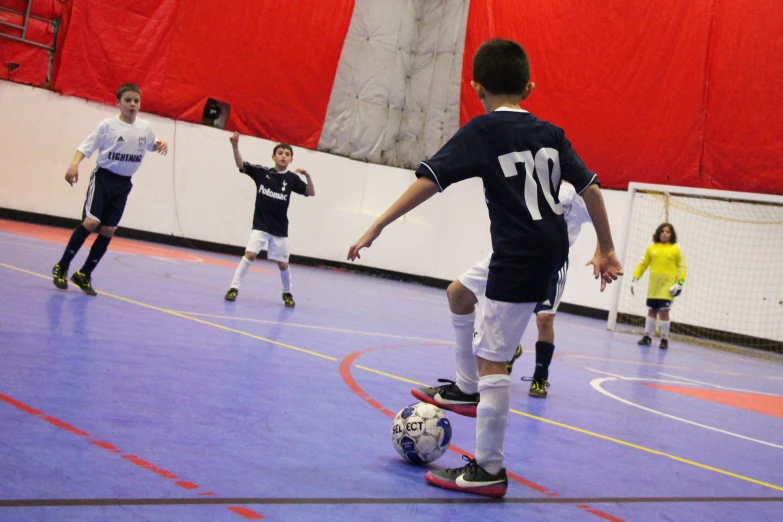 there is a young soccer player on the court about to kick the ball