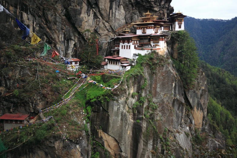 the buddhist structure on the cliff is perched high above the town