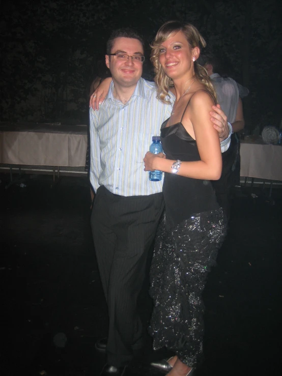 a man and a woman posing in front of a table