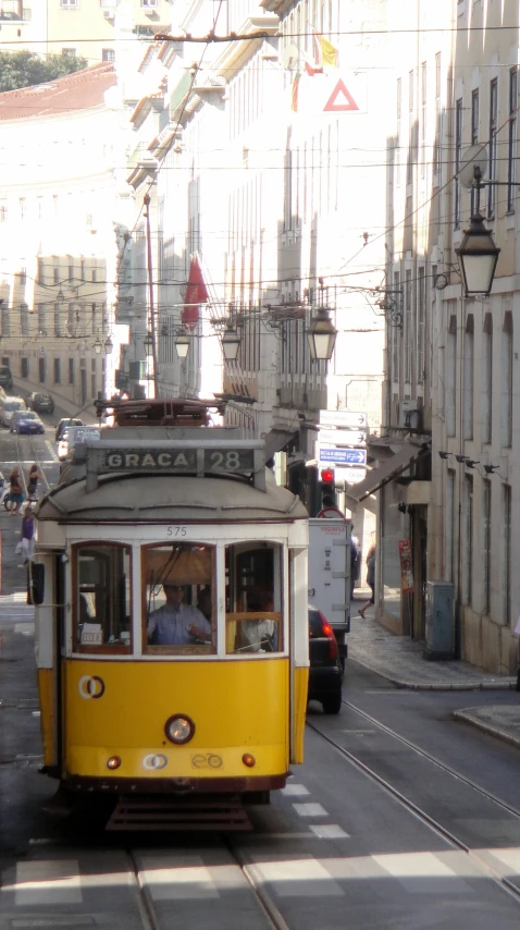 a yellow trolley passing through a city street