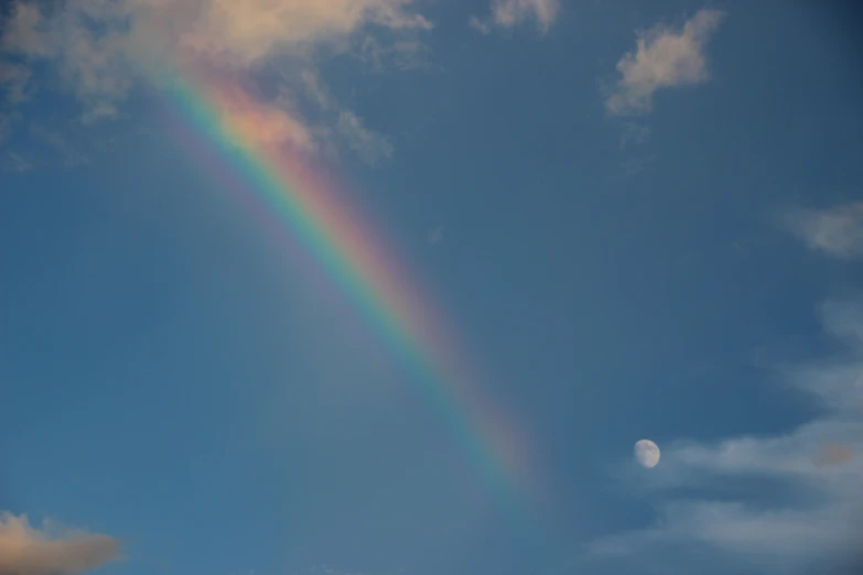 the rainbow is shining in the sky above the moon