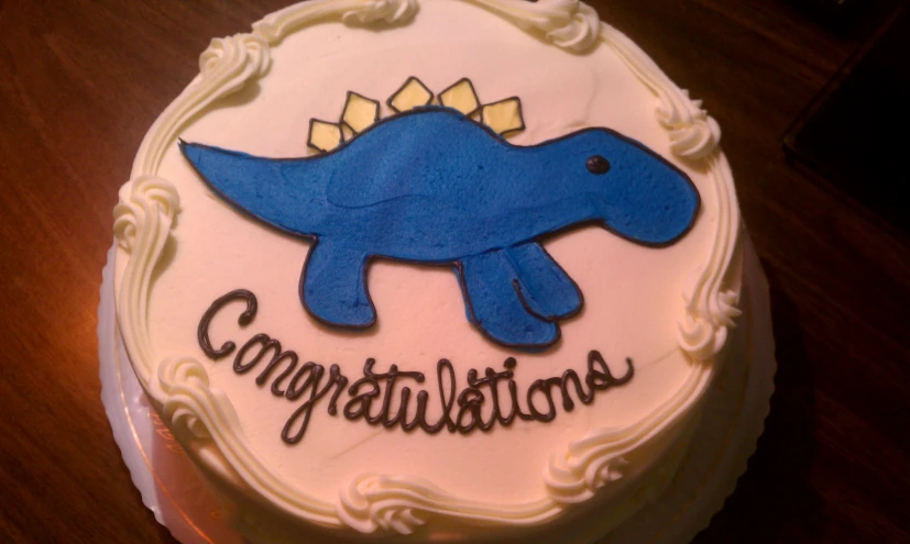 a birthday cake decorated with a cartoon dinosaur