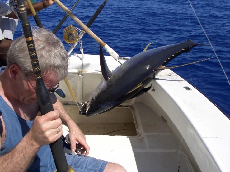 an old man on a boat has some tuna