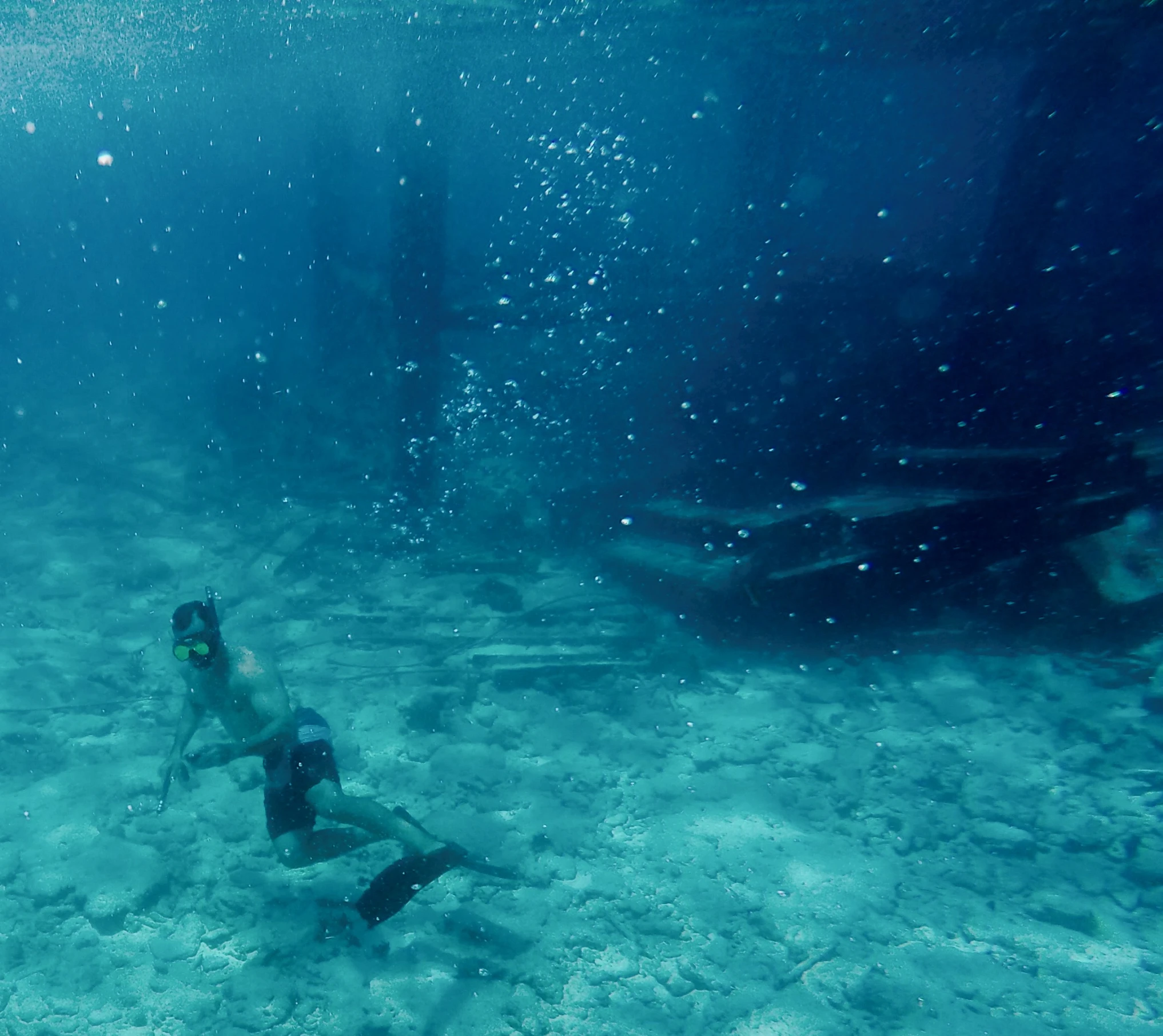 a person with a helmet is swimming in the ocean