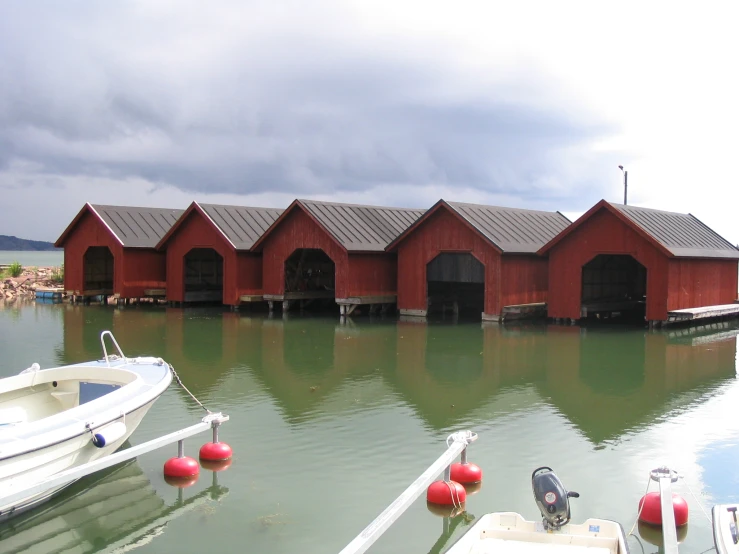 boats docked near a red building on water