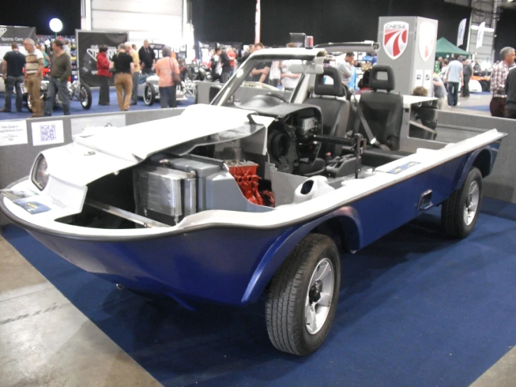 people looking at an unusual car that appears to be built