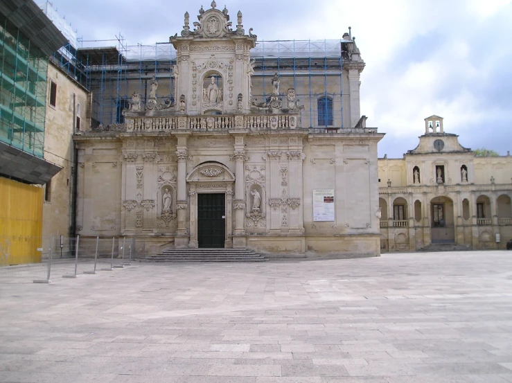 a po taken on a gloomy day shows a large building with a very intricate front and a clock tower