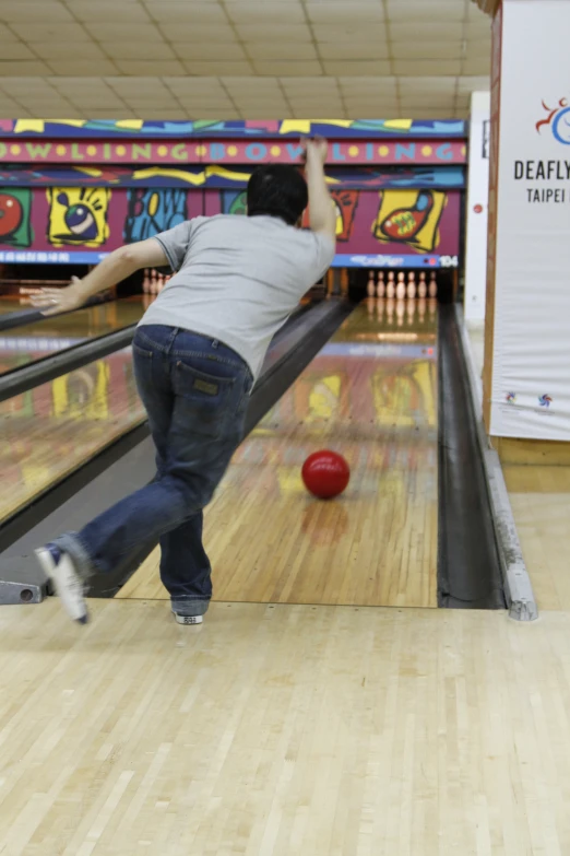 the man is going down the lane to catch the bowling ball