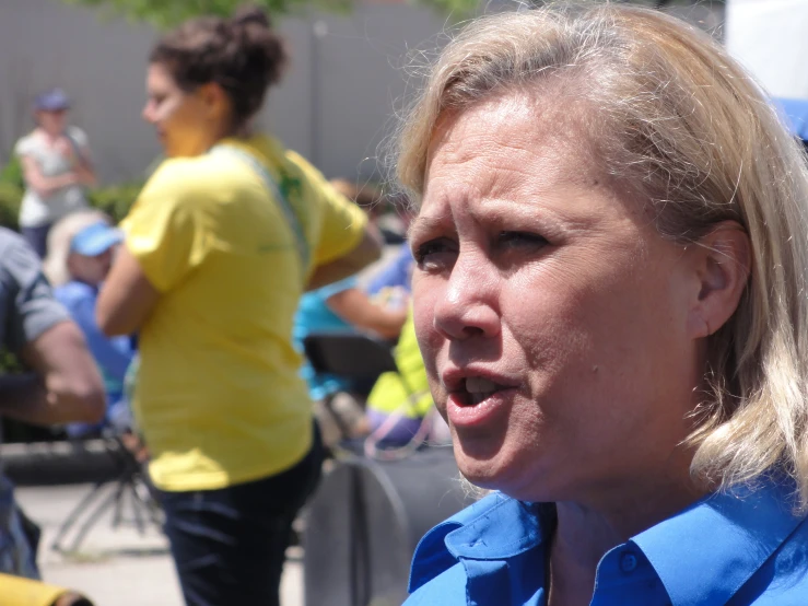 a woman is speaking while a man looks on