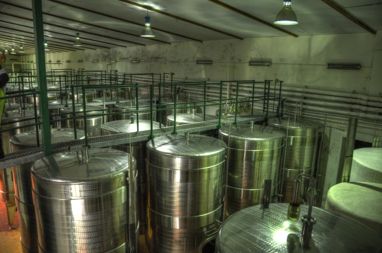 several stainless steel tanks in the middle of a room