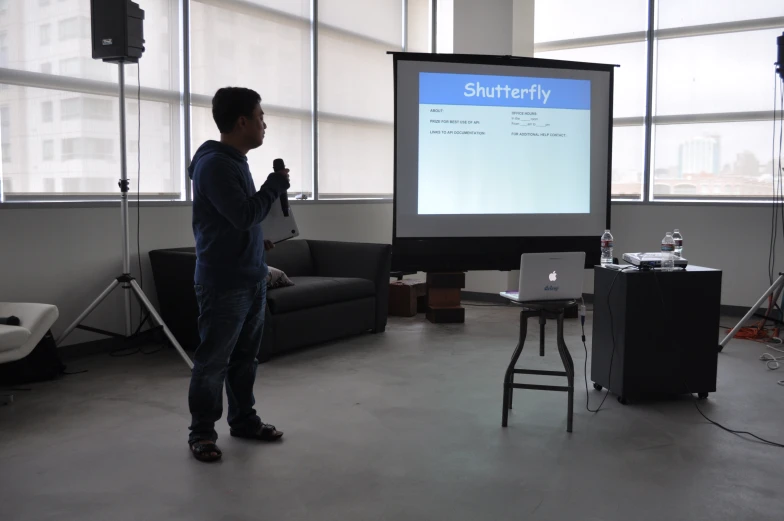 a man in the room presenting soing on the projector screen