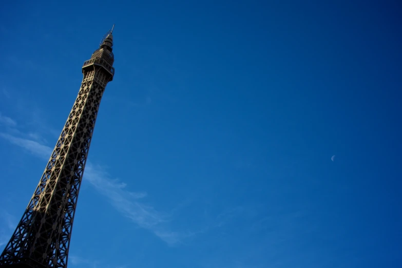 a very tall tower with the moon in the background