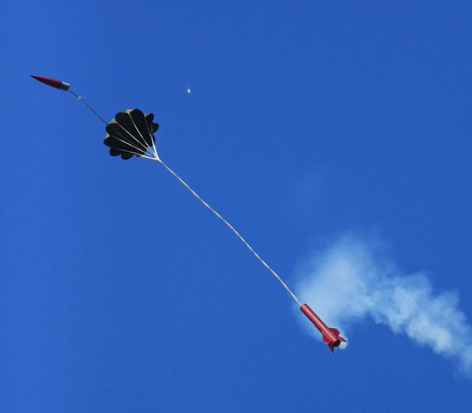 a kite flying through the sky with white steam