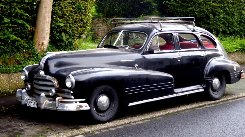 an old fashion black sedan on the road