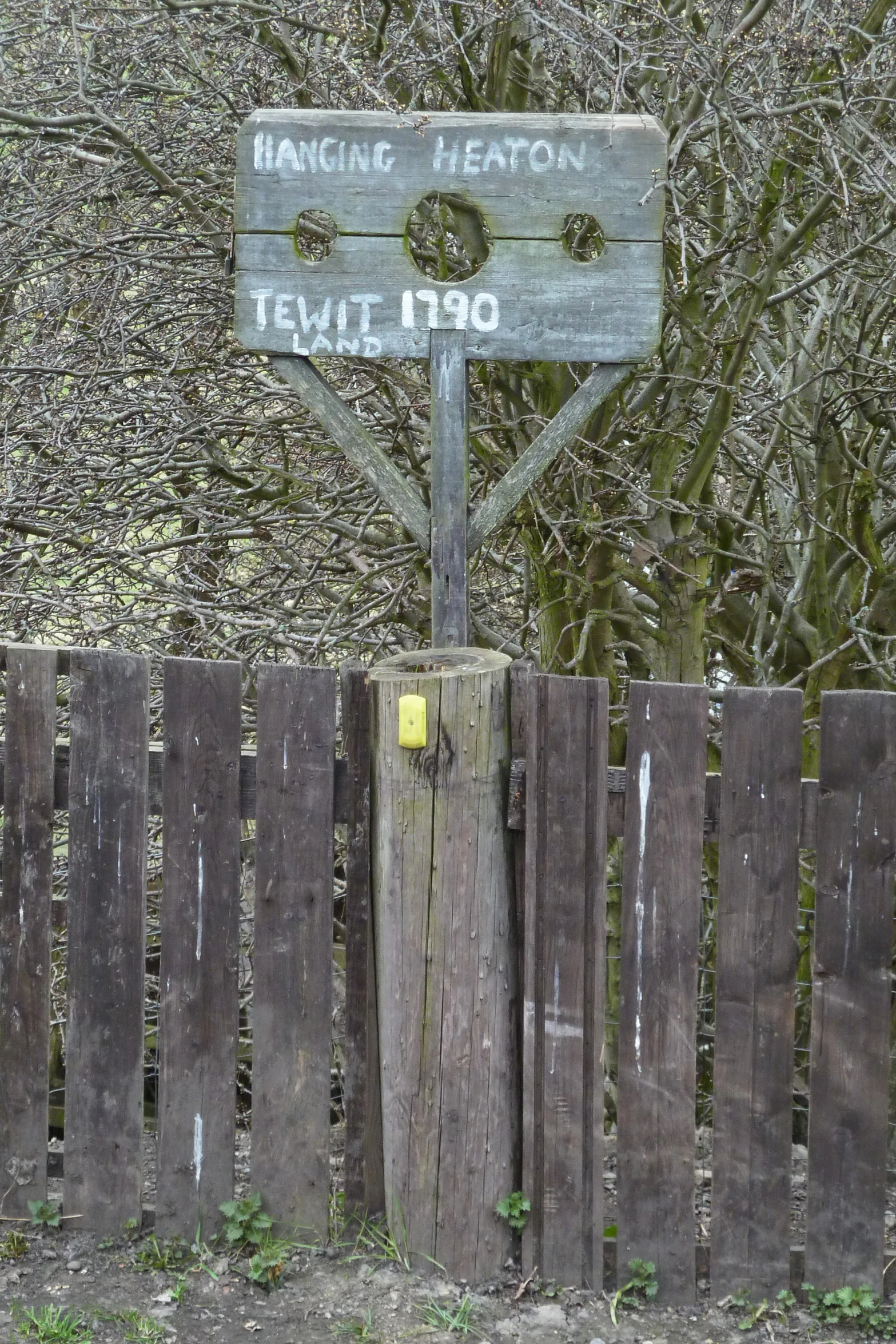 a wooden fence surrounds a wooden fence and an old looking sign