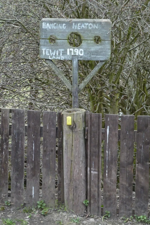 a wooden fence surrounds a wooden fence and an old looking sign