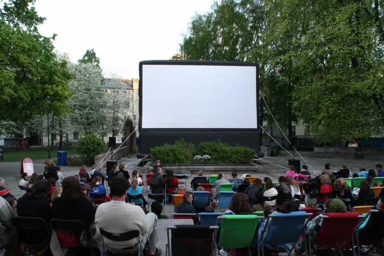 a group of people that are sitting in front of a movie screen