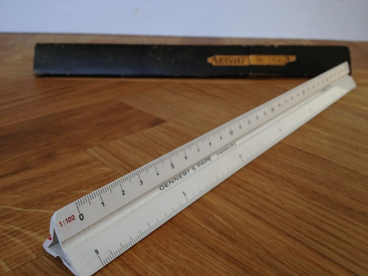 a ruler with a wooden surface and a black box behind it