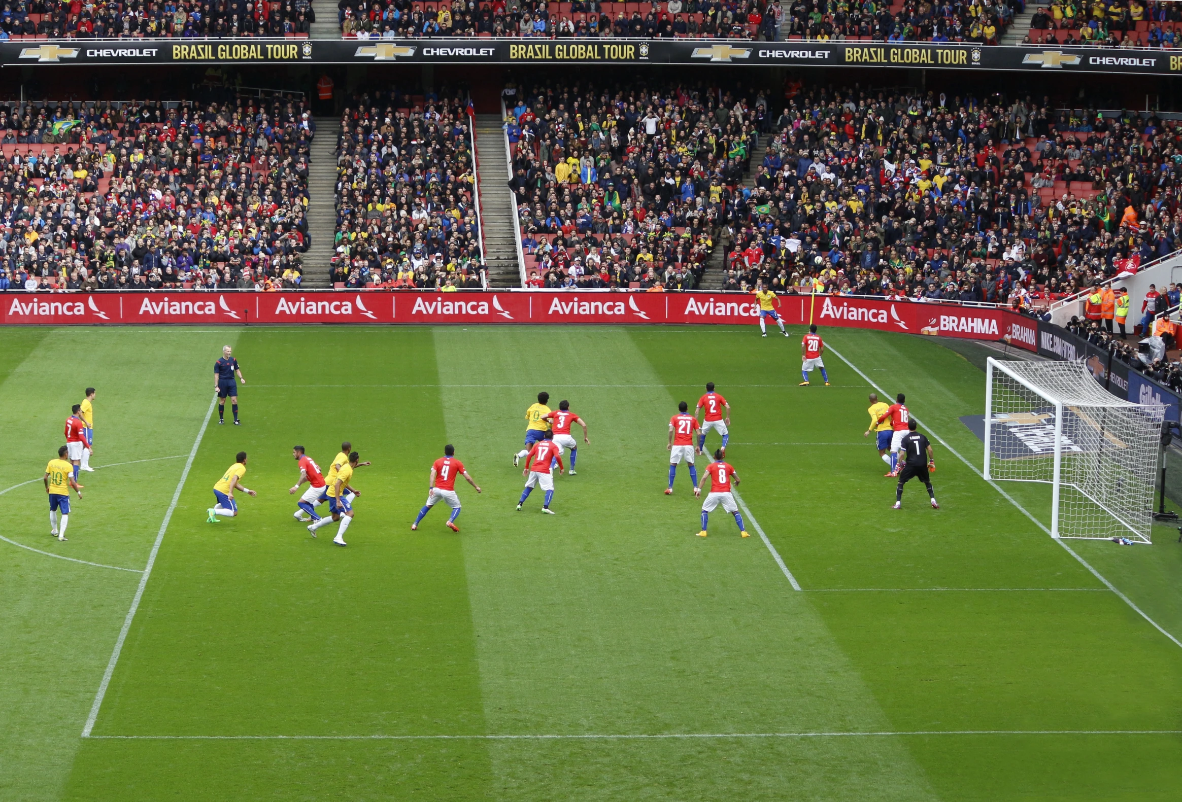 soccer players on a field with a stadium full of fans