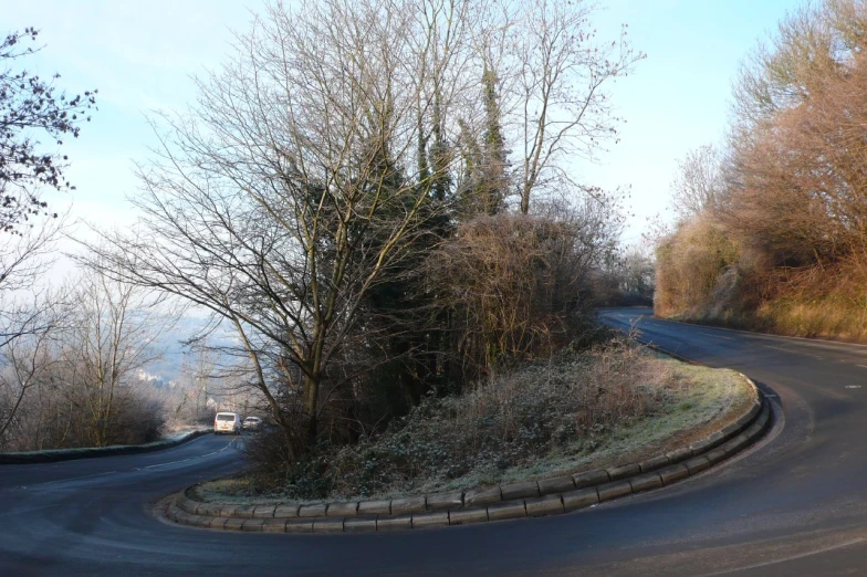 a curve in the street near a hill