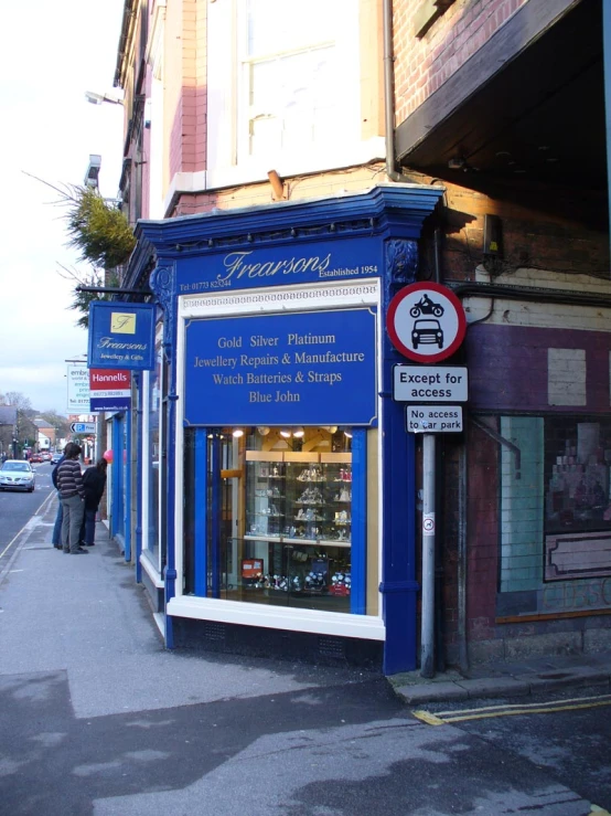 a sidewalk that has some blue storefronts on it