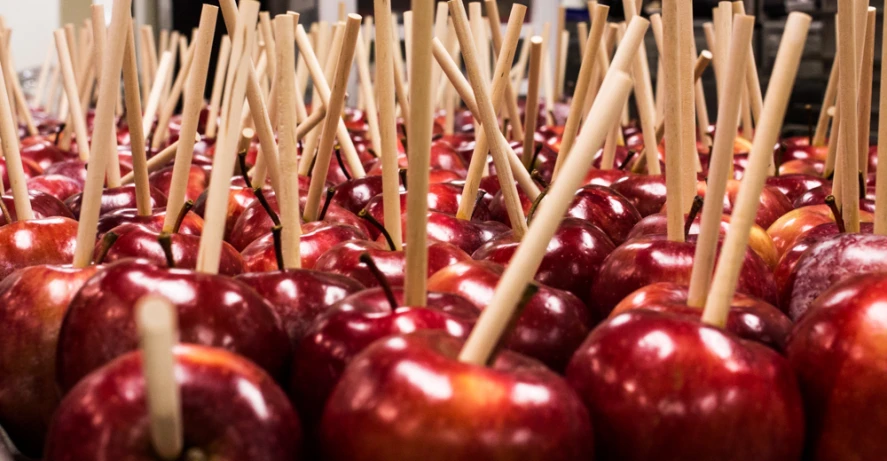 a pile of apples that have toothpicks stuck in them