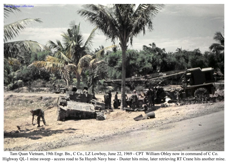 people stand around wrecked cars and trucks on the side of the road