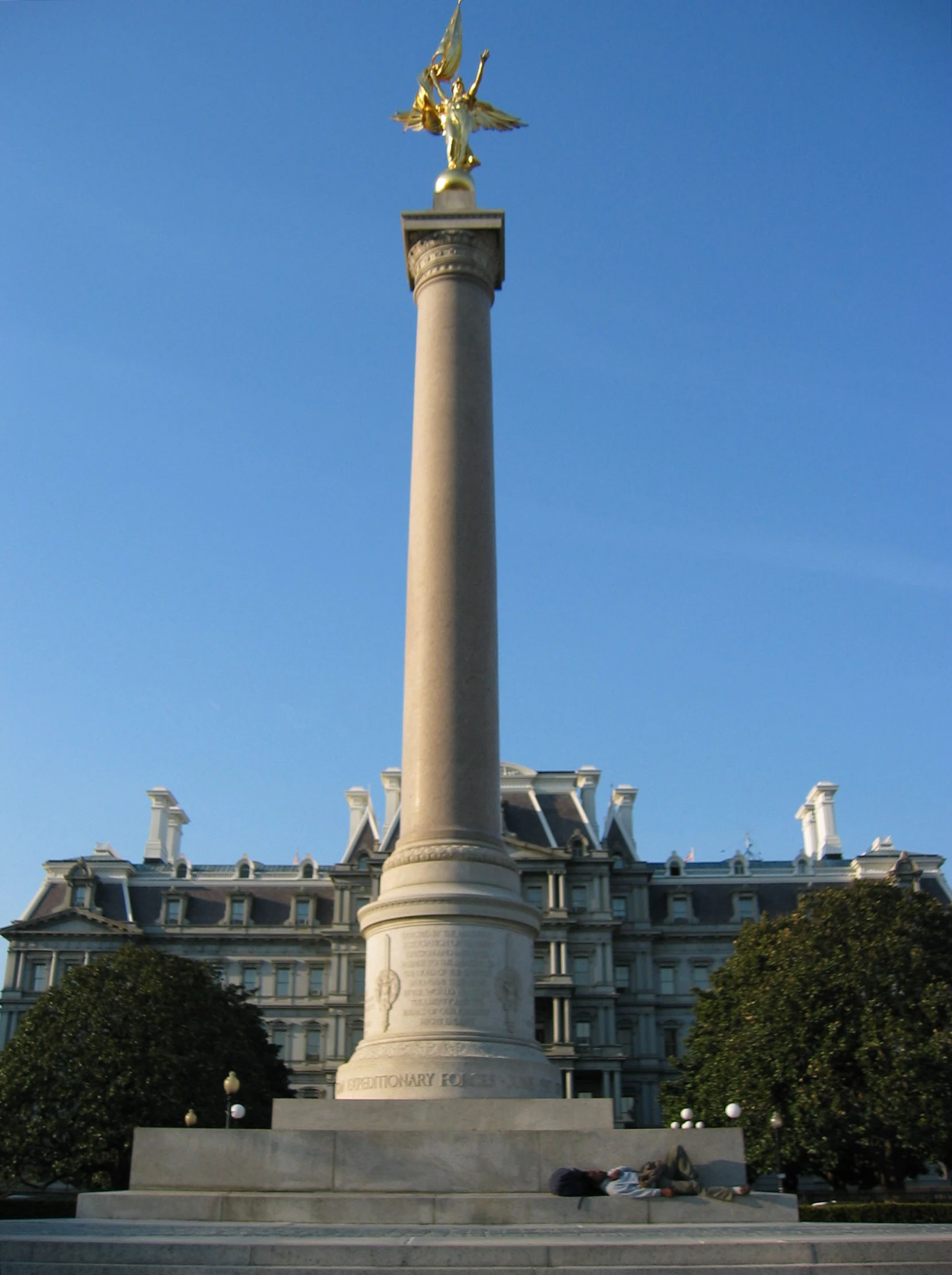 a large statue standing in front of a tall building