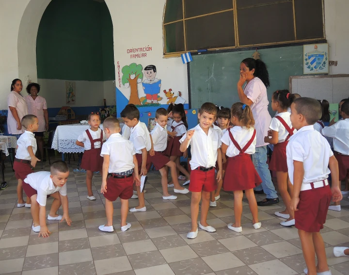 a group of s wearing red shorts in front of a school wall