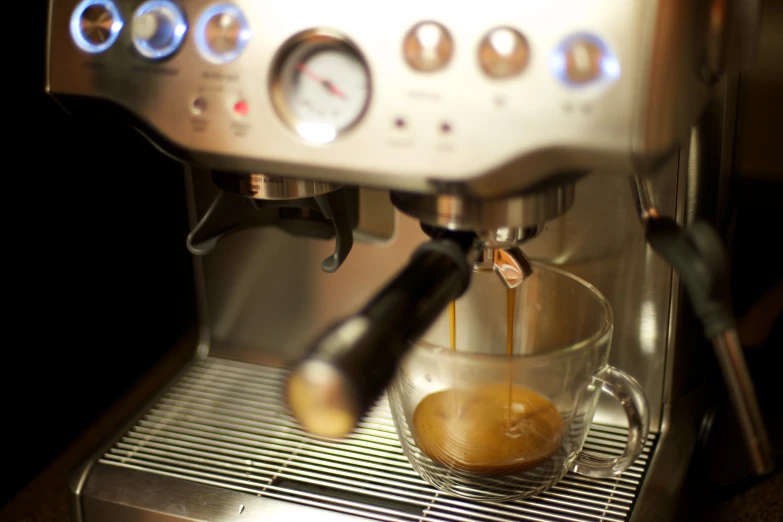 a espresso machine with some liquid coming out of the top