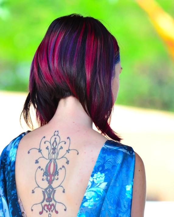 a back view of a woman wearing a blue shirt