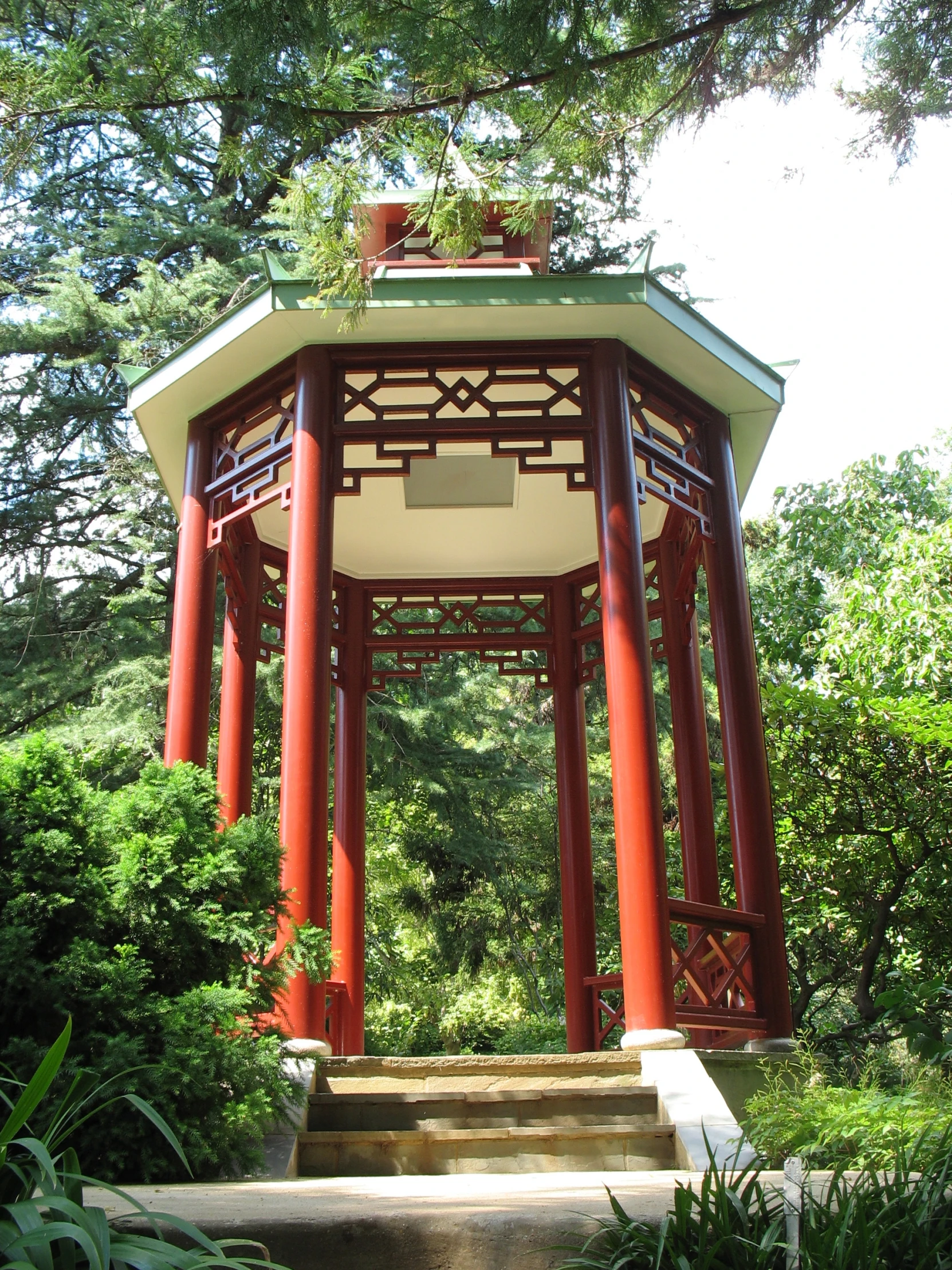 a small gazebo sits beneath a big tree