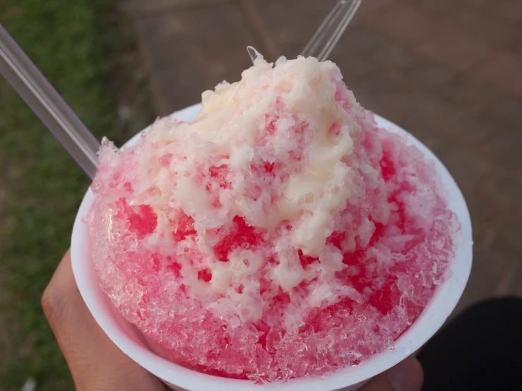 the ice cream is pink and has white topping