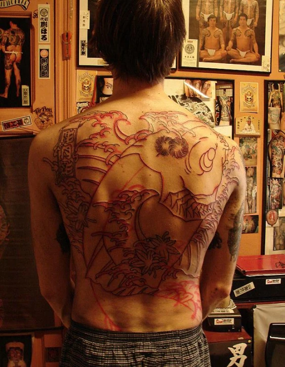 a man has many tattoos on his back