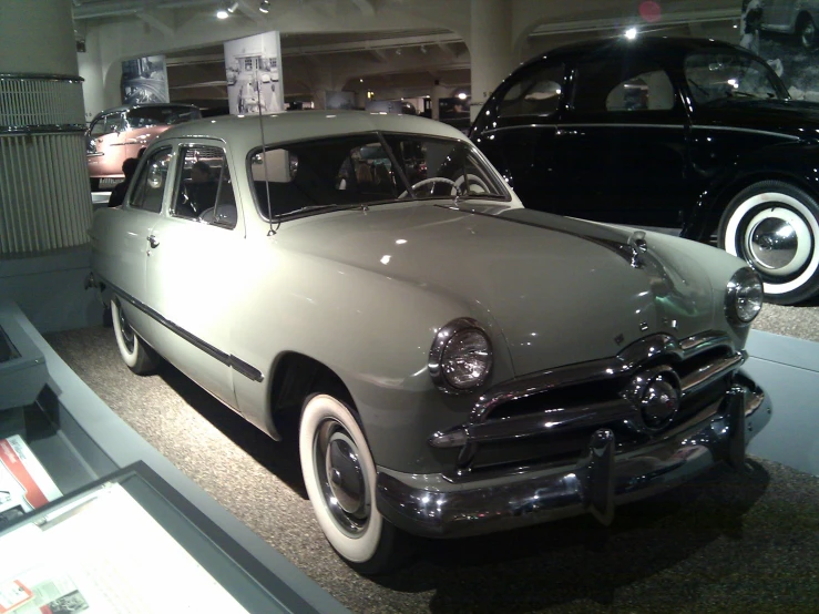 vintage cars are shown in a museum on display