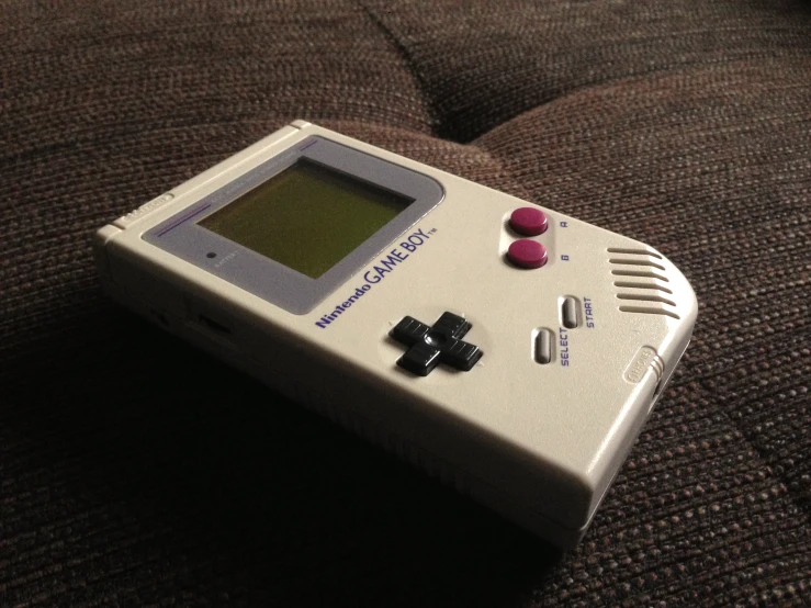 a handheld game system sitting on a couch