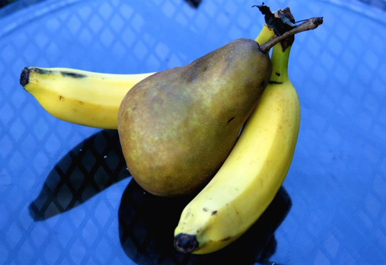 two pieces of fruit sitting on top of blue table